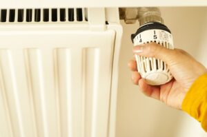 Purger ses radiateurs : main réglant le robinet d'un radiateur de chauffage central