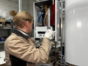 Technicien contrôlant une chaudière murale au gaz pour prévenir le monoxyde de carbone